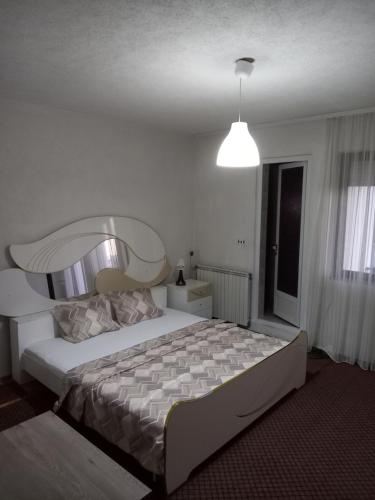 een slaapkamer met een groot bed met een groot hoofdeinde bij Ambient Apartments in Struga