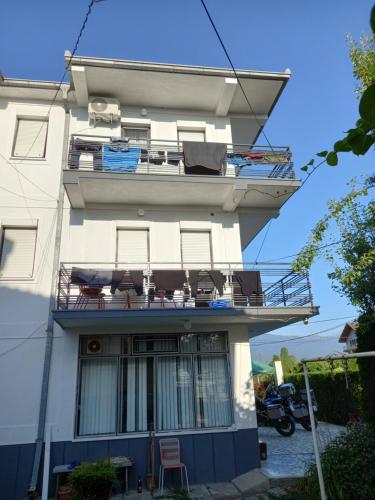 een wit gebouw met stoelen en een balkon bij Ambient Apartments in Struga