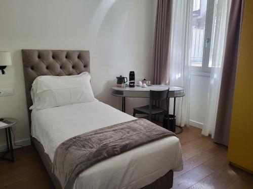 una camera con un letto e un tavolino di Sempione Boutique Hotel a Stresa