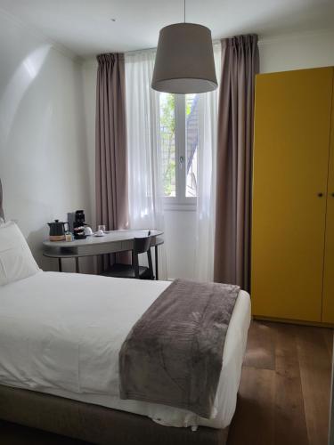 una camera con letto, tavolo e finestra di Sempione Boutique Hotel a Stresa