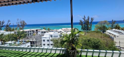 a view of the beach from the balcony of a building at Luxury Apartment 150 m from the beach in Flic-en-Flac