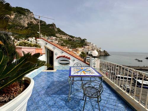 una mesa en un balcón con vistas al océano en Holidays Baia D'Amalfi, en Amalfi