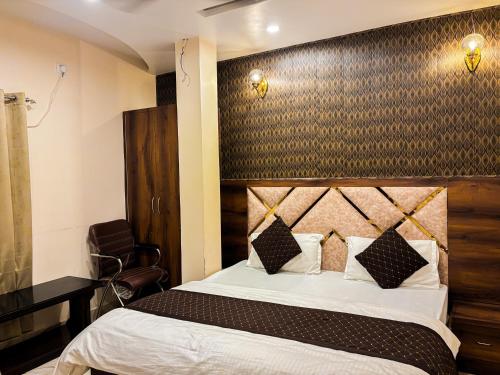 1 dormitorio con 1 cama grande y cabecero de madera en HOTEL VIA GANGA INN ! గంగా ఇన్ ద్వారా హోటల్ VARANASI! FULLY AIR-CONDITIONED HOTEL AT PRIME LOCATION WITH ROOFTOP GANGES VIEW! 2 Min walking distance from ASSI GHAT ,NEAR KASHI VISHWANATH TEMPLE, en Varanasi