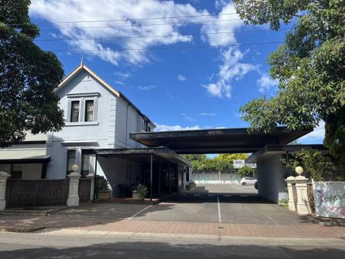 ein leerer Parkplatz vor einem weißen Gebäude in der Unterkunft Jasper Motor Inn in Adelaide