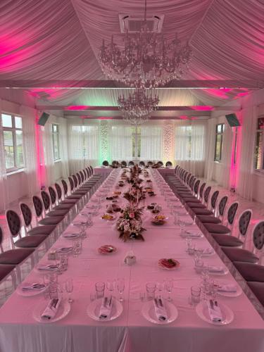 a long table in a large room with pink lighting at База відпочинку "РіверСайд" СВІТЛО Є ЗАВЖДИ in Novomoskovsʼk