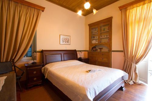 um quarto com uma cama e uma cómoda e cortinas em Archontiko em Mystras