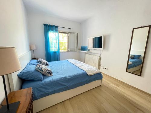 um quarto com uma cama com lençóis azuis e um espelho em Villa Tany em Capoliveri