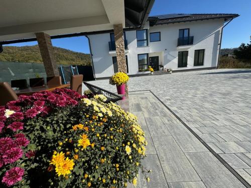 patio z ławką i kwiatami przed budynkiem w obiekcie Vila Diamond Lux&Spa w mieście Sovata