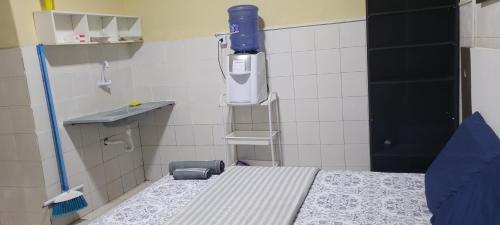 ein Krankenhauszimmer mit einem Bett und einer blauen Flasche an der Wand in der Unterkunft Kitnet 17 in São Luís