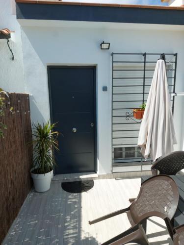 une terrasse avec une porte noire et quelques plantes dans l'établissement Estudio Caño Guerrero Matalascañas, à Matalascañas