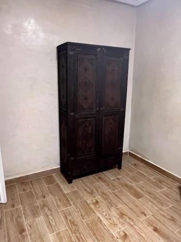 einem Holzschrank in einer Ecke eines Zimmers in der Unterkunft Appartement proche aeroport in Marrakesch