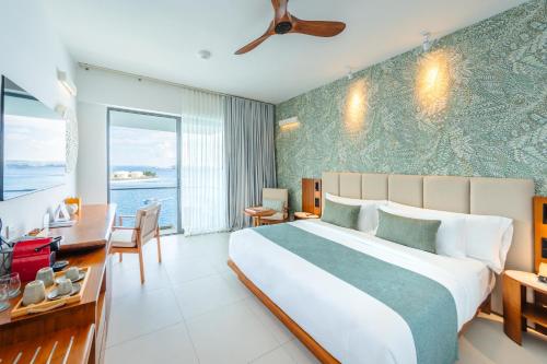 ein Schlafzimmer mit einem großen Bett, einem Tisch und Stühlen in der Unterkunft Barceló Nasandhura Male in Male City