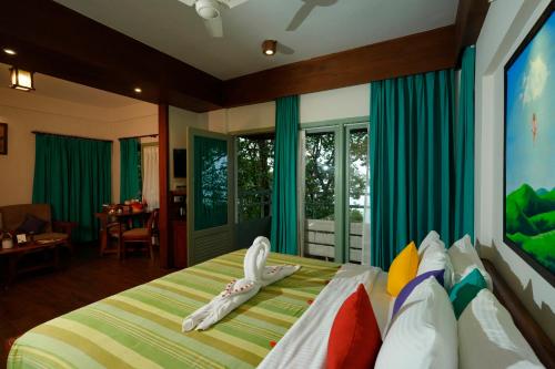 una camera da letto con un letto con un uccello sopra di Blackberry Hills Munnar Nature Resort & Spa a Munnar