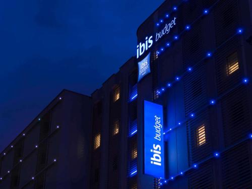 un bâtiment avec un panneau la nuit dans l'établissement ibis budget Lyon Centre Confluence, à Lyon