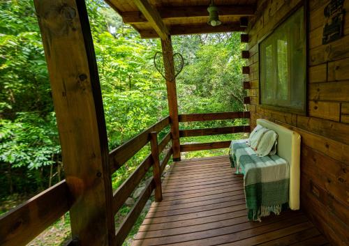 a porch of a cabin with a bench on it at Cabaña Win en el Bosque, RUNA YAKU in San Lorenzo