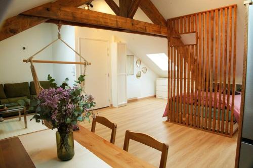 una sala de estar con un jarrón de flores sobre una mesa en Appartement de charme à Nancy, en Nancy