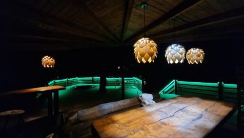 Cette chambre sombre dispose d'une table en bois et de lumières. dans l'établissement Complex Hyzhky, à Yaremtche