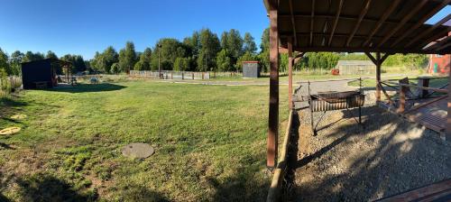 vistas a un patio con una valla y un campo de césped en Cabañas El Tronco Viejo, en Curacautín