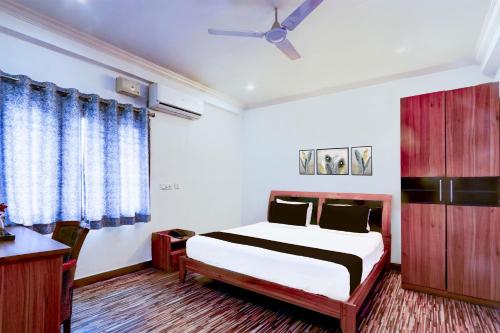 a bedroom with a bed and a ceiling fan at Hotel O VG Grand in Madhapur