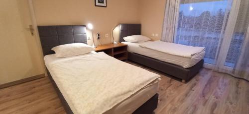 een kamer met 2 bedden, een bureau en een raam bij Studio apartmani OK Lipik in Lipik