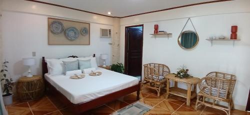 um quarto com uma cama, uma mesa e cadeiras em Kerusso Haven em Puerto Princesa