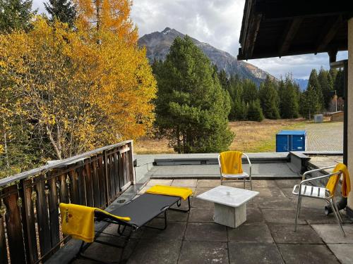 patio z ławką i krzesłami na tarasie w obiekcie Winterzsuber Lenzerheide w mieście Lenzerheide