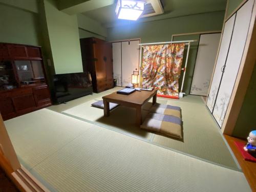 - un salon avec une table et un tapis dans l'établissement Osaka Ukiyoe Ryokan, à Osaka