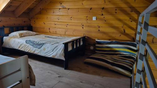 een slaapkamer met een bed in een blokhut bij Chalet des parapentes in Saint-Leu