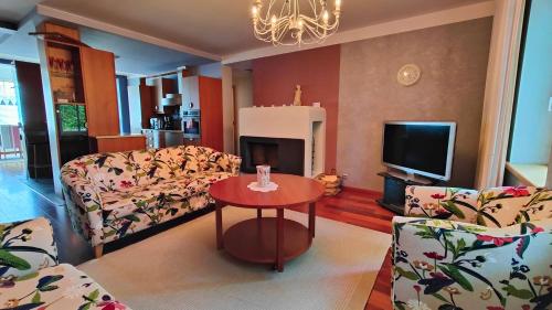 a living room with a couch and a table and a tv at Papli Villa in Pärnu