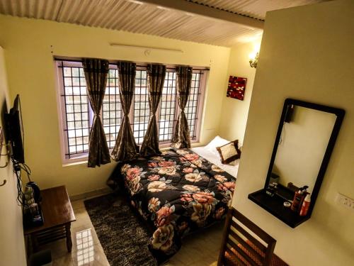 una camera con letto, specchio e finestra di BOB's Heaven Bungalow a Ooty