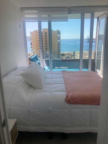 - une chambre avec un lit et une vue sur l'océan dans l'établissement Hermoso Departamento Playa La Herradura, à Coquimbo