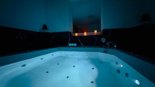 a bath tub in a room with a mirror at Hedonist Spa Jacuzzi Sarajevo in Sarajevo