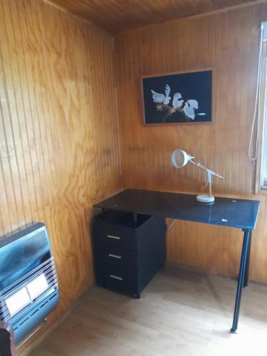 - un bureau avec une lampe et une imprimante dans la chambre dans l'établissement La casona de don Juan, à Coyhaique