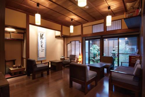 un soggiorno con sedie, tavoli e finestre di Ryokan Tanabe a Takayama