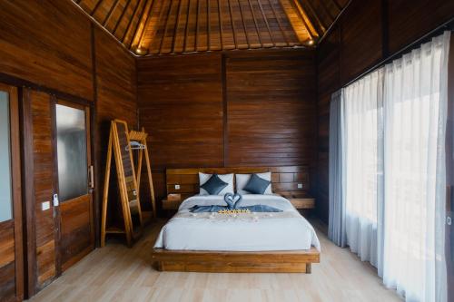 - une chambre avec un lit dans une pièce en bois dans l'établissement The Akasea Villa Bali, à Ungasan