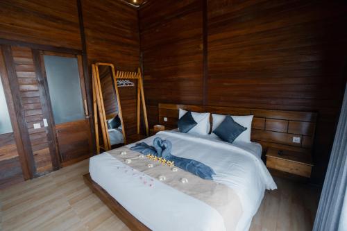 - une chambre avec un lit blanc et des murs en bois dans l'établissement The Akasea Villa Bali, à Ungasan