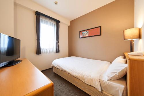 a hotel room with a bed and a television at Hotel JIN Morioka Ekimae in Morioka