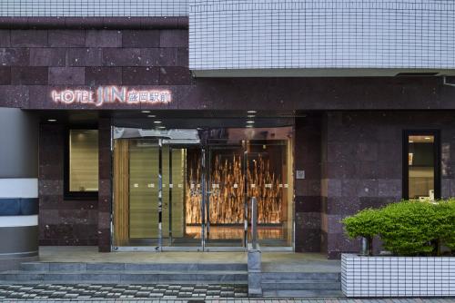 a store front of a building with a sign on it at Hotel JIN Morioka Ekimae in Morioka