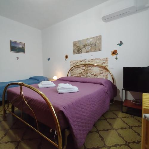 a bedroom with a bed with a purple blanket at La Casetta Di Cotignola in Cotignola