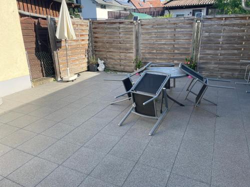 een patio met een tafel en stoelen en een hek bij Gästehaus Jeurissen ca 5 Autominuten von Europa-Park Rust oder Rulantica in Kappel-Grafenhausen