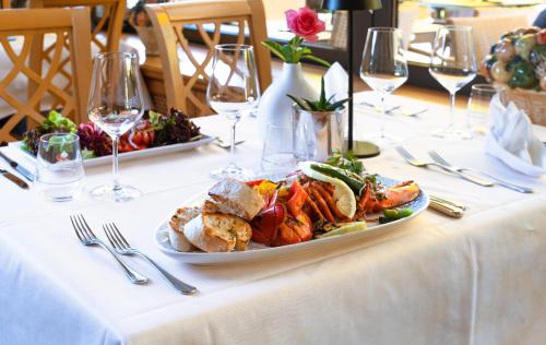 un tavolo con un piatto di bicchieri da cibo e vino di Parkhotel an der Therme a Bad Krozingen