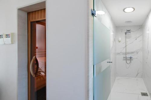 bagno con doccia e porta in vetro di Hotel Gala Split a Podstrana