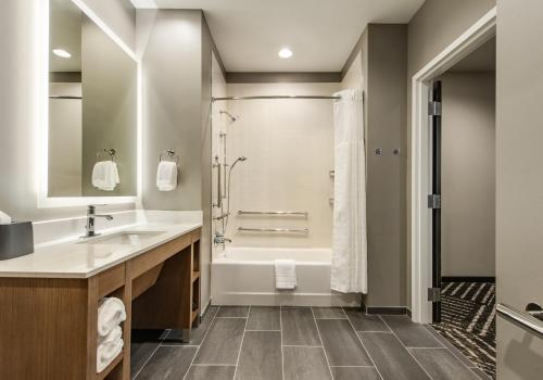 La salle de bains est pourvue d'une baignoire, d'un lavabo et d'une douche. dans l'établissement Hyatt House Bwi Airport/Baltimore, à Linthicum