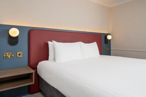 een slaapkamer met een groot bed met een rood hoofdeinde bij London Croydon Aerodrome Hotel, BW Signature Collection in Croydon