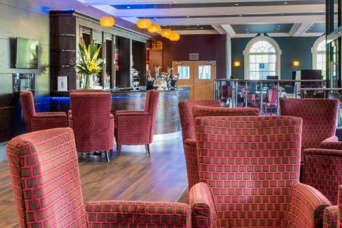 een restaurant met rode stoelen en een bar bij London Croydon Aerodrome Hotel, BW Signature Collection in Croydon