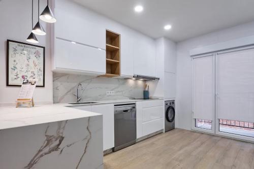 a white kitchen with a sink and a dishwasher at Apartamento NUEVO en el centro de LEON in León