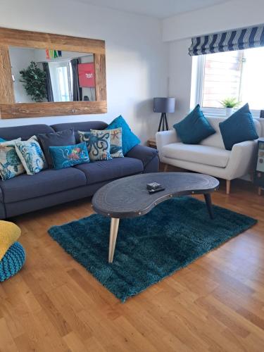 een woonkamer met een bank en een salontafel bij Fistral beach apartment in Newquay