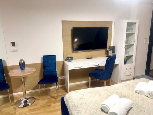 Schlafzimmer mit einem Bett und einem Schreibtisch mit einem TV in der Unterkunft Seaside - Apartamenty KOMFORT, widok na morze, Parking in Kołobrzeg