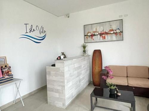 una sala de estar con sofá y un cartel en la pared en Hotel Isla Vela Paracas, en Paracas