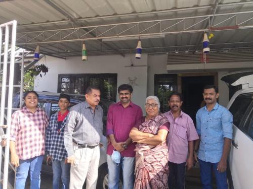 a group of people standing in front of a car at SpiceGreen Homestay,Thekkady in Thekkady